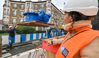 Agent du SEDIF regardant une canalisation de transport surélevée