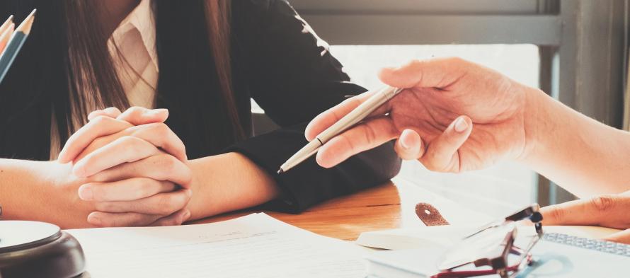 2 personnes discutant autour de dossiers administratifs